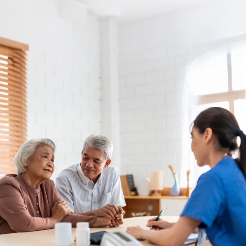 Healthcare professional consulting with elderly couple—personalized senior care services at Neighborhood Health.