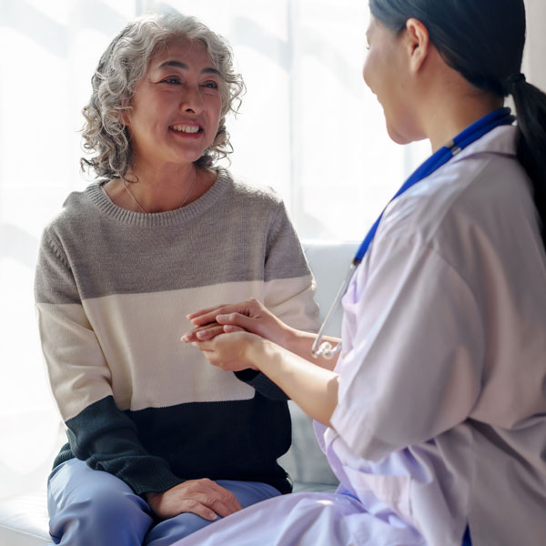 Two adult women in conversation sitting on couch. Behavioral Health Services - Opioid Use Disorder Assistance. Neighborhood Health
